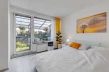 Schlafzimmer mit Balkon  Dachgeschoss-Wohnung Vollvermietetes Wohn- und Geschäftshaus mit Mietsteigerungspotenzial